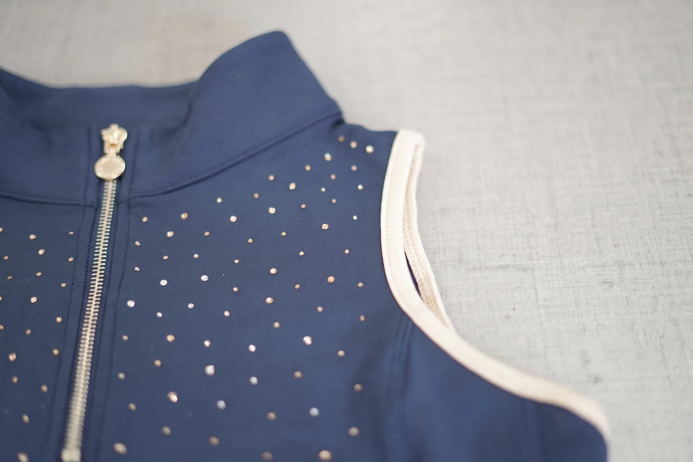 Semis de strass et liseré crème sur une chemise de concours d’équitation marine, vue rapprochée