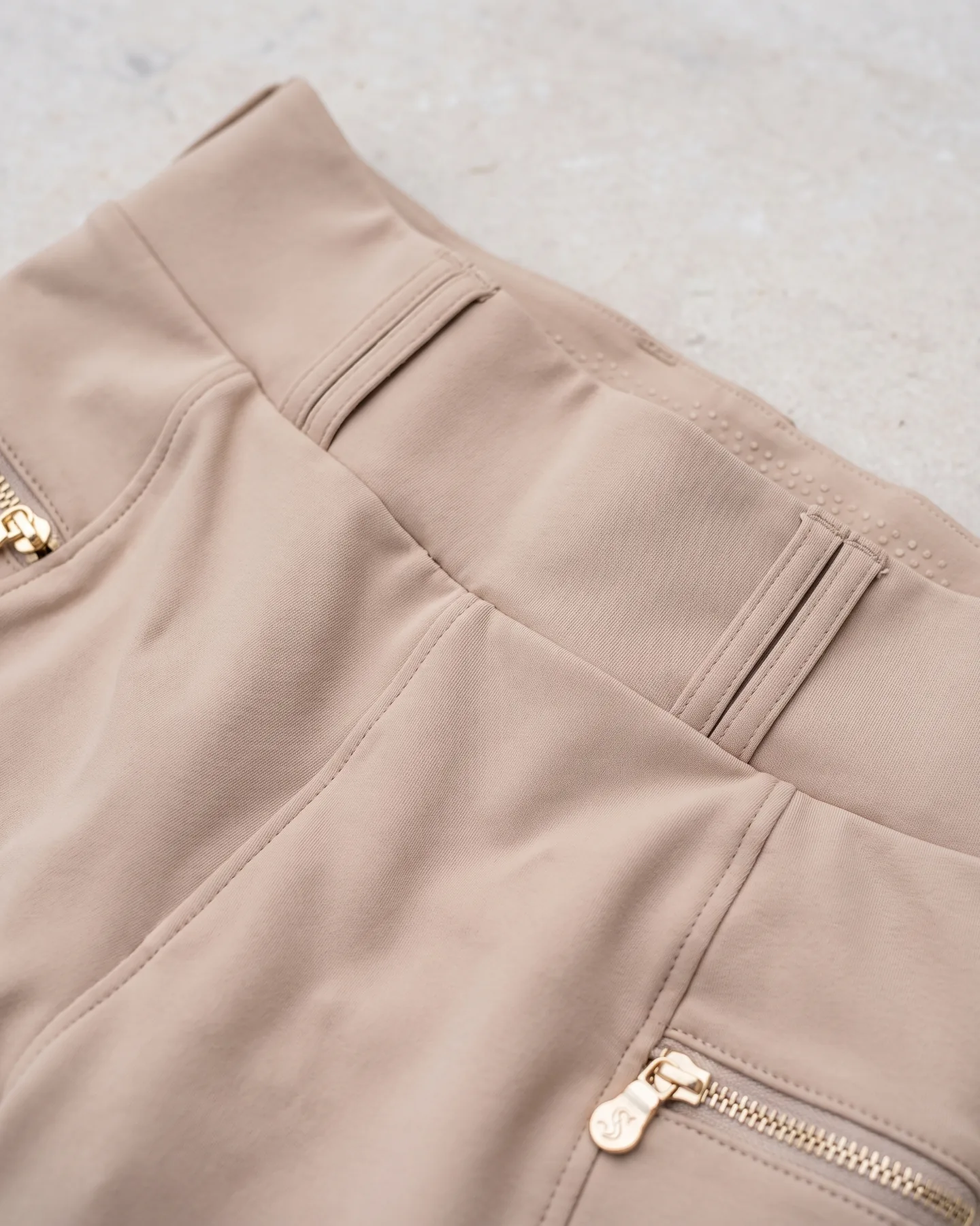 Ceinture de pantalon d’équitation avec plaque métal au logo, vue de près
