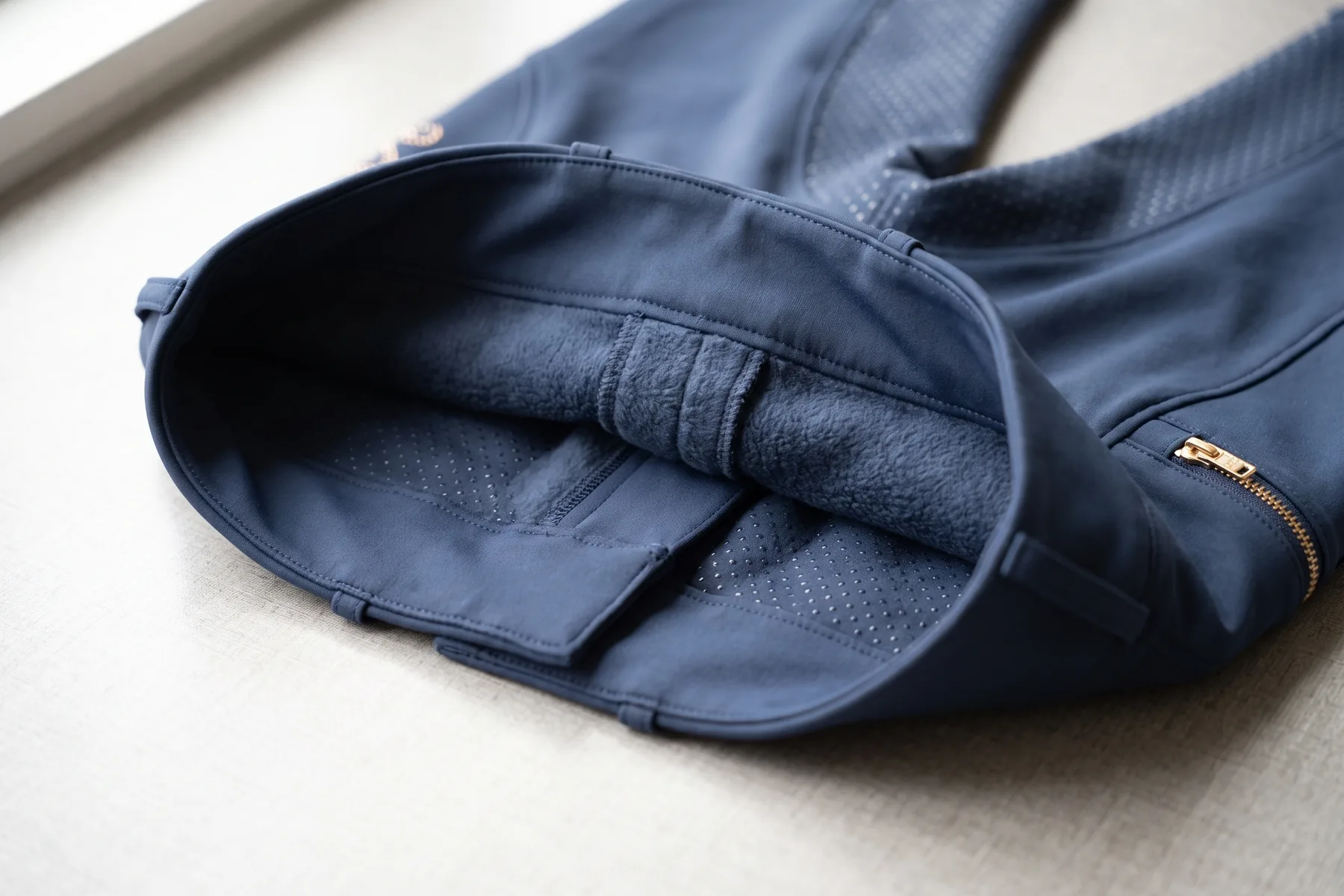 Intérieur d’un pantalon d’équitation marine retourné, doublure polaire grise sous la ceinture