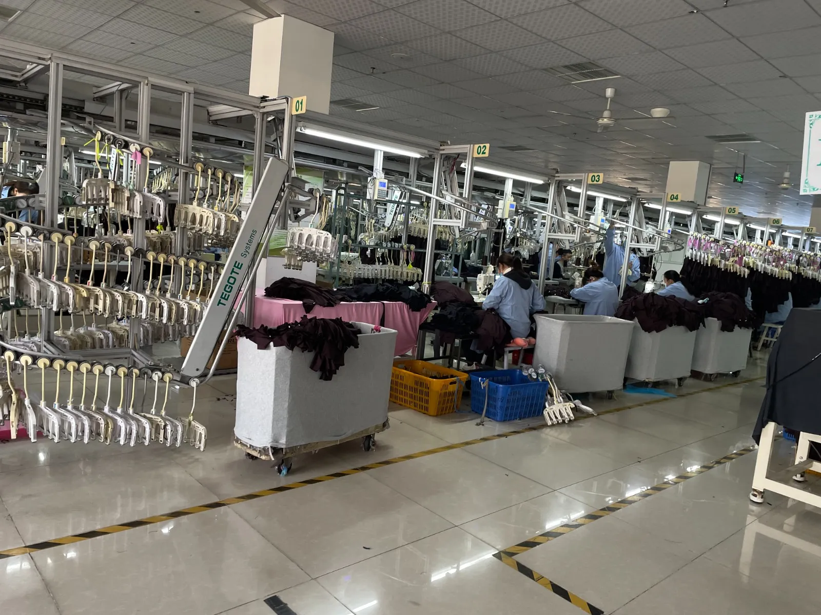 Atelier de couture : rangées de postes sous le convoyeur suspendu