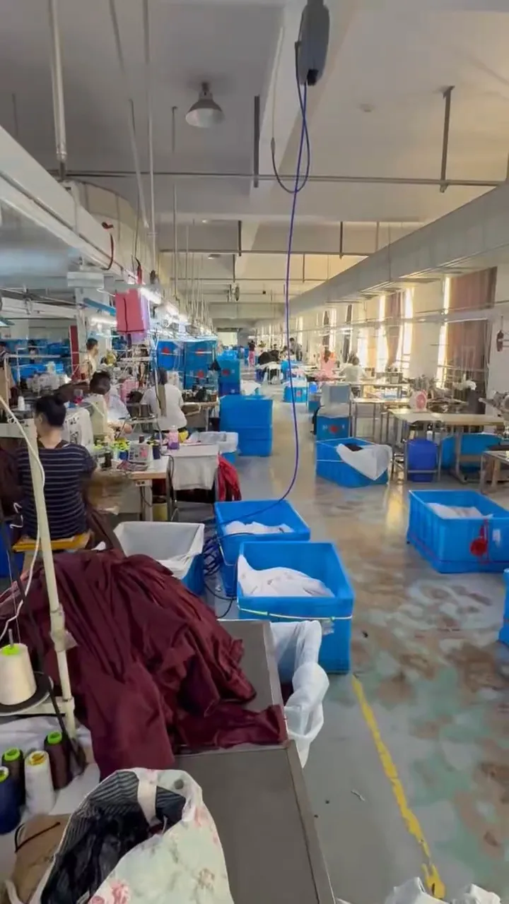 Salle de couture : rangées de machines et de postes
