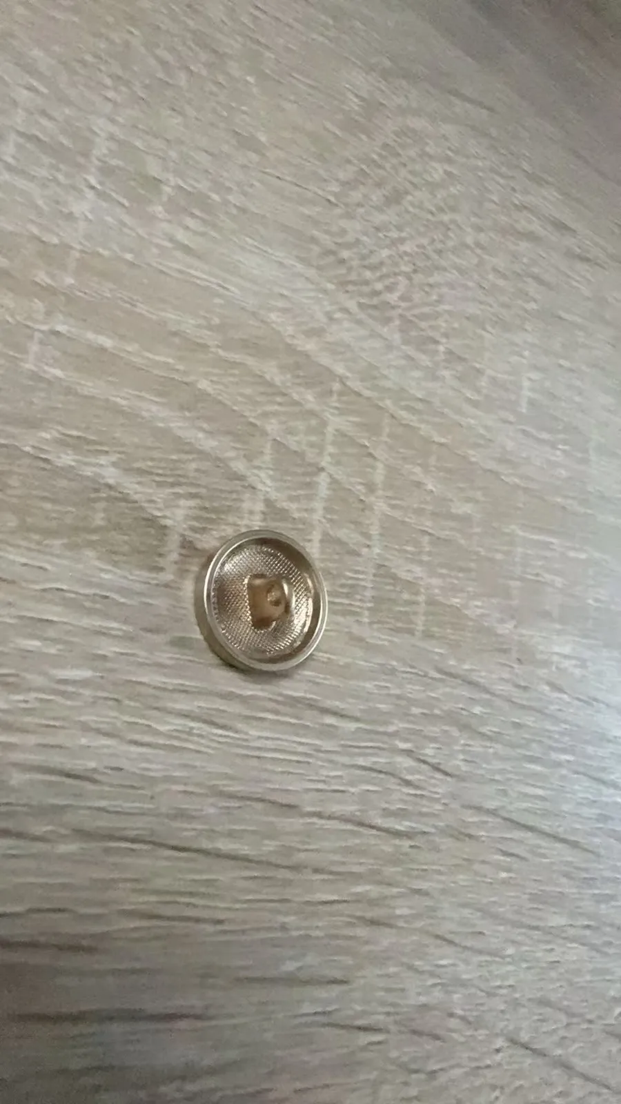 Bouton métal personnalisé vu du revers, avec sa queue de fixation