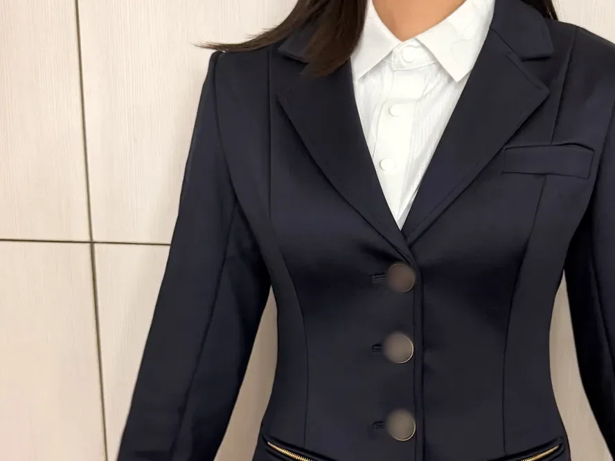 Essayage d’un échantillon de veste de concours marine portée sur une chemise blanche