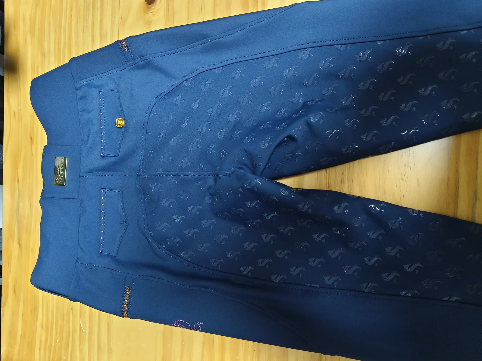 Grip silicone à motif répété sur la jambe d’un pantalon d’équitation bleu