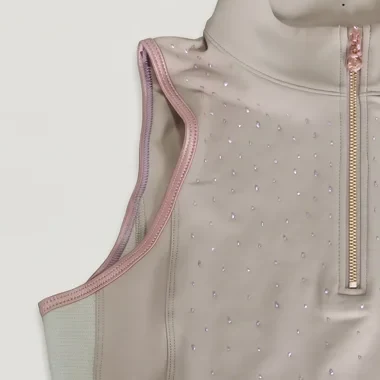 Emmanchure d’un haut de concours sable bordée d’un liseré rose