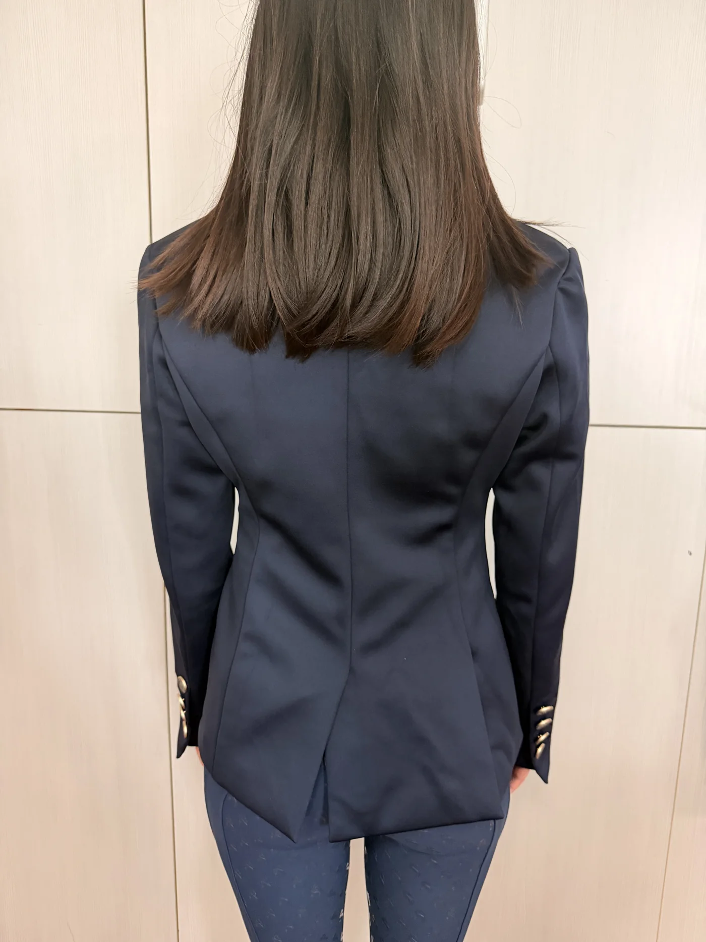 Échantillon de veste de concours marine porté, vu de dos : taille cintrée, fente dos et quatre boutons au poignet